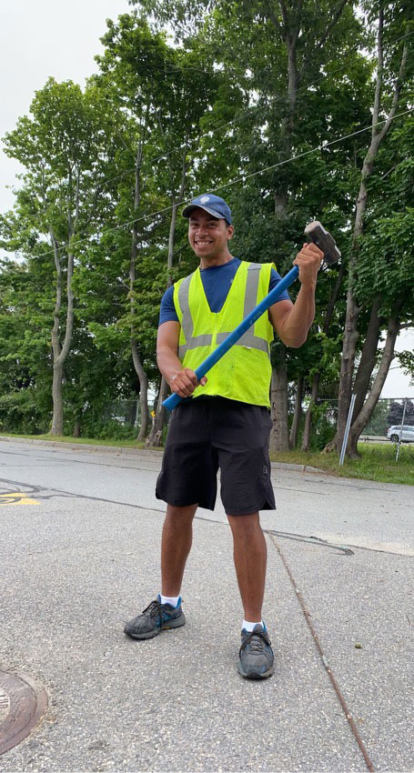 Quinn holding a large hammer in the road
